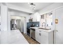 Modern kitchen features white cabinets, stainless steel appliances, tile backsplash, and quartz countertops at 10555 Montview Blvd, Aurora, CO 80010