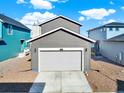 Exterior view of a two-car garage, with a well-maintained driveway and neutral siding complementing the surrounding landscape at 470 Kiowa Ave, Bennett, CO 80102