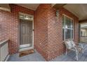 Close up of the brick front porch with a welcome mat, chair, and exterior lighting at 3434 Fantasy Pl, Castle Rock, CO 80109