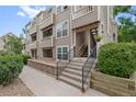 Multi-story condo building featuring covered stairways, neutral siding, and nicely landscaped surroundings at 5765 W Atlantic Pl # 104, Lakewood, CO 80227