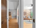 Hallway view showcasing an open concept living room with a brick wall and hardwood floors at 529 E 14Th Ave # 10, Denver, CO 80203