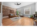 Comfortable living room with a brick wall, hardwood floors, and an open layout at 529 E 14Th Ave # 10, Denver, CO 80203