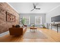 Bright living room featuring hardwood floors, a brick wall, and large windows for plenty of natural light at 529 E 14Th Ave # 10, Denver, CO 80203