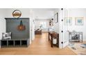 Inviting hallway featuring wood floors, a built-in bench, and a view into the kitchen at 8357 W 68Th Ln, Arvada, CO 80004