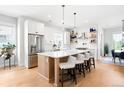 Beautiful kitchen with stainless steel refrigerator, large island with seating, and open shelves at 8357 W 68Th Ln, Arvada, CO 80004