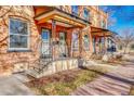 Charming brick home featuring dual entryways with decorative iron railings on the front porch at 707 27Th St, Denver, CO 80205