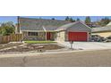 Charming single-Gathering home with brick accents, a red garage door, and a well-maintained front yard at 7814 W Ontario Pl, Littleton, CO 80128