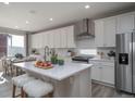 Bright kitchen with white cabinetry, stainless steel appliances, and a large center island with seating at 21947 E 51St Dr, Aurora, CO 80019