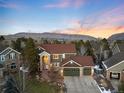 Gorgeous aerial view of a two-story home with a three car garage nestled in a serene neighborhood with mountain views at 6 White Alder, Littleton, CO 80127