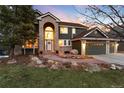 Charming two-story home with brick accents, manicured lawn, mature trees, and a three-car garage at 6 White Alder, Littleton, CO 80127