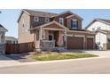 Well-maintained two-story home with a three-car garage, front porch, and nicely landscaped yard at 1334 Barberry Trl, Elizabeth, CO 80107