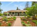 Charming home featuring a lush, landscaped front yard with a long walkway and covered front porch at 403 Anderson St, Castle Rock, CO 80104
