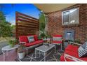 Inviting patio with brick flooring, cozy seating area, and a modern water feature on brick wall at 1335 Jasmine St, Denver, CO 80220