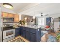 Updated kitchen with two tone cabinets, stainless steel appliances, and bar seating that opens to the living area at 1833 N Williams St # 201, Denver, CO 80218