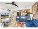 Open concept living room with breakfast bar, ceiling fan, and views into the kitchen at 1833 N Williams St # 201, Denver, CO 80218