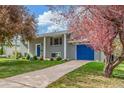 Charming two-story home with a well-manicured lawn and a blue door and garage at 3841 W Quinn Pl, Denver, CO 80236