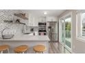 Bright kitchen featuring stainless steel appliances, white cabinets, and a sliding glass door to the outdoor patio at 3841 W Quinn Pl, Denver, CO 80236