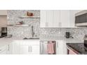 Bright white kitchen with stainless steel appliances, modern counters and backsplash at 3841 W Quinn Pl, Denver, CO 80236
