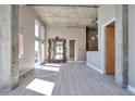 Open living space with oversized mirror, hardwood style floors, concrete pillars and high ceilings at 1475 Delgany St # 807, Denver, CO 80202