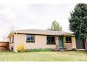 Charming one-story home boasts an appealing brick facade and a lush green lawn at 3890 Moore St, Wheat Ridge, CO 80033