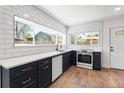 Modern kitchen featuring navy cabinets, stainless steel appliances, and a large window bringing in natural light at 4745 N Clay St, Denver, CO 80211