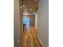 Hallway featuring gleaming wood floors leading to a bright dining area, showcasing an open floor plan at 23014 Milford Ln, Parker, CO 80138