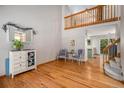 Bright and airy living room with hardwood floors, a vaulted ceiling, and open access to the kitchen at 9640 Moss Rose Cir, Highlands Ranch, CO 80129