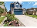 Attractive two-story blue house with brick accents, a driveway and landscaped garden at 9546 High Cliffe St, Highlands Ranch, CO 80129