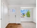 Bright entryway with wood floors, a white front door and a large window providing natural light at 12678 W Dorado Pl, Littleton, CO 80127