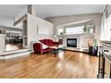 Bright living room with fireplace, hardwood floors, large windows, and a comfortable layout for entertaining at 4649 Fenwood Dr, Highlands Ranch, CO 80130