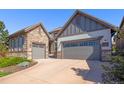 Charming home with stone and siding, complemented by a three-car garage and tidy landscaping at 10687 Featherwalk Way, Highlands Ranch, CO 80126