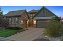 Home exterior showing stone details, three-car garage, and a well-kept lawn, perfect for curb appeal at 10687 Featherwalk Way, Highlands Ranch, CO 80126