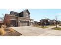View of home exterior with large driveway and well manicured lawn at 24325 E Ada Pl, Aurora, CO 80018