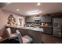 Modern kitchen with gray cabinets, stainless steel appliances, and a breakfast bar with seating at 12242 Bannock Cir # D, Denver, CO 80234