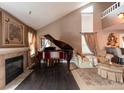 Elegant living room featuring a fireplace, baby grand piano, and high ceilings with large windows at 12242 Bannock Cir # D, Denver, CO 80234
