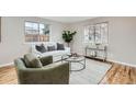A bright and airy living room with a white sofa, area rug, and hardwood floors at 5235 Dover St, Arvada, CO 80002