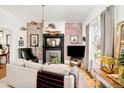 Cozy living room featuring a brick accent wall, fireplace, and hardwood floors at 432 N Ogden St, Denver, CO 80218