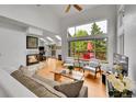 Bright living room featuring high ceilings, large windows, wood floors, a ceiling fan, and a fireplace at 766 Chimney Creek Dr, Golden, CO 80401
