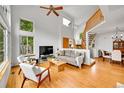 Open-concept living room featuring wood floors, high ceilings, large windows, and a staircase to the second floor at 766 Chimney Creek Dr, Golden, CO 80401