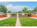 Inviting single-story brick home featuring a well-manicured lawn and walkway under a bright blue sky at 3216 Revere St, Aurora, CO 80011
