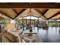 Expansive living room featuring vaulted ceilings, dark floors, walls of windows, and impressive stone fireplace at 5565 Osage Way, Larkspur, CO 80118