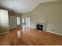 Spacious living room with a fireplace, hardwood floors, vaulted ceiling, and an abundance of natural light at 1216 S Flat Rock Cir, Aurora, CO 80018