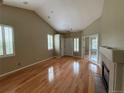 Bright living room featuring hardwood floors, a fireplace, and large windows with stylish white shutters at 1216 S Flat Rock Cir, Aurora, CO 80018