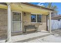 Cozy front porch with classic columns, a decorative metal bench, and an ornate security door at 12333 Edwards Pl, Denver, CO 80239