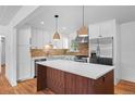 Bright kitchen featuring white cabinets, stainless steel appliances, and a butcher block island at 7736 Vallejo St, Denver, CO 80221
