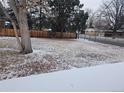 Large, fenced backyard with mature trees and a mix of grass and fallen leaves, providing a peaceful outdoor space at 2907 S Upham St, Denver, CO 80227