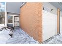 Side view of townhome entry and attached garage, snow on ground at 1693 Carr St # A, Lakewood, CO 80214