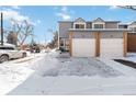 Front view of a two-story townhome with attached garage in winter at 1693 Carr St # A, Lakewood, CO 80214