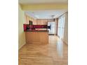 Open kitchen with stainless steel appliances, a breakfast bar, and hardwood flooring at 13304 E Asbury Dr, Aurora, CO 80014