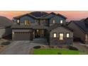 Beautiful two-story home featuring a well-maintained yard, a two-car garage, and a charming stone facade at 18541 W 93Rd Pl, Arvada, CO 80007